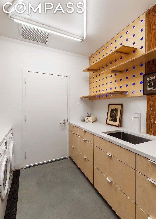 washroom with cabinets, sink, and washer and clothes dryer