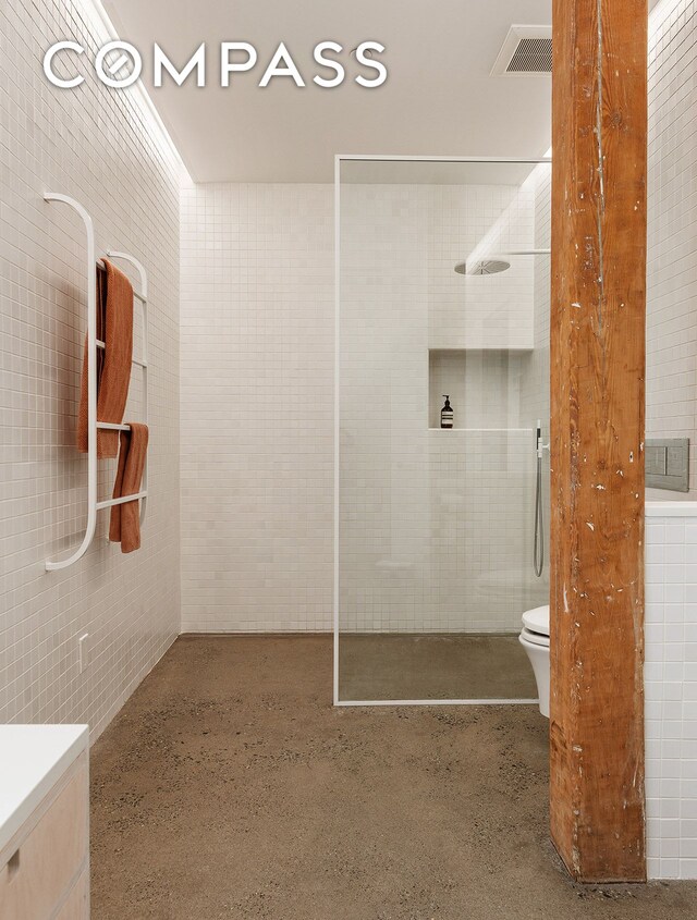 bathroom featuring vanity and tile walls