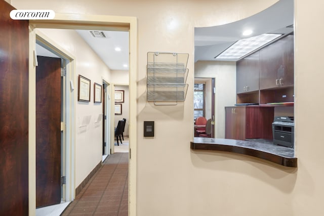 hall featuring dark tile patterned flooring