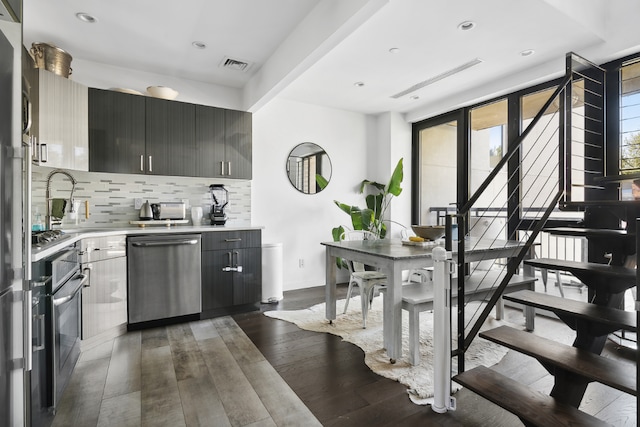 kitchen with dishwasher, dark hardwood / wood-style floors, sink, and backsplash