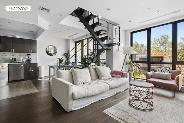 living room with dark hardwood / wood-style flooring and a wall of windows