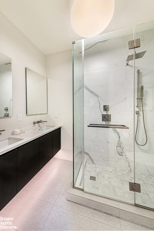 bathroom featuring double vanity, a marble finish shower, and a sink