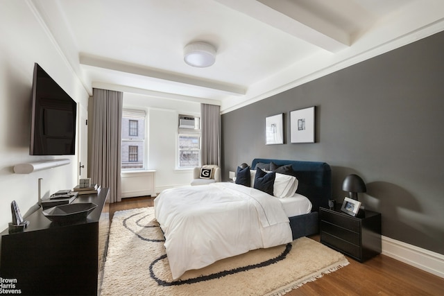 bedroom with baseboards, beamed ceiling, a wall mounted air conditioner, and dark wood-type flooring