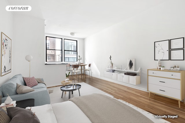 living room with visible vents, baseboards, and wood finished floors