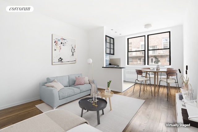 living room with hardwood / wood-style flooring, baseboards, and visible vents