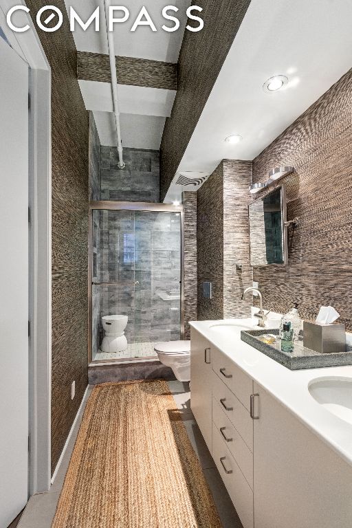 bathroom featuring beamed ceiling, vanity, toilet, and an enclosed shower