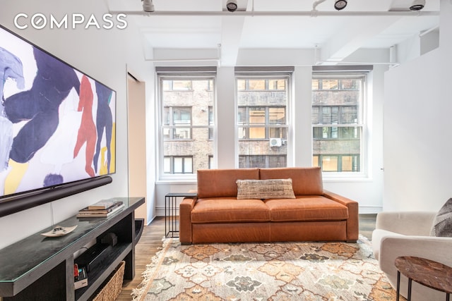 interior space featuring beamed ceiling, wood finished floors, and baseboards