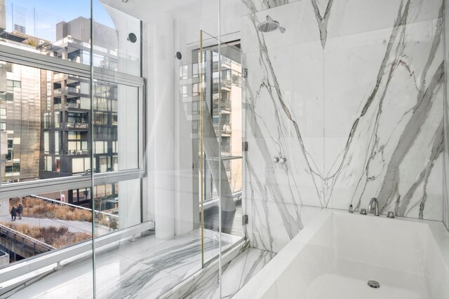 515 W 23rd St Unit 6Flr, New York City, NY 10011 - full bathroom featuring a tub to relax in, marble finish floor, and a marble finish shower