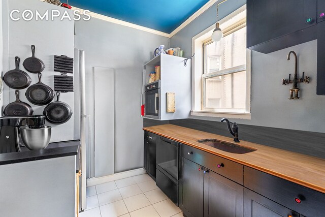 kitchen with light tile patterned flooring, dishwasher, sink, hanging light fixtures, and crown molding