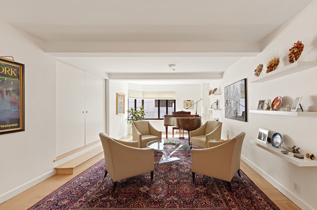 sitting room featuring beamed ceiling and light wood-type flooring