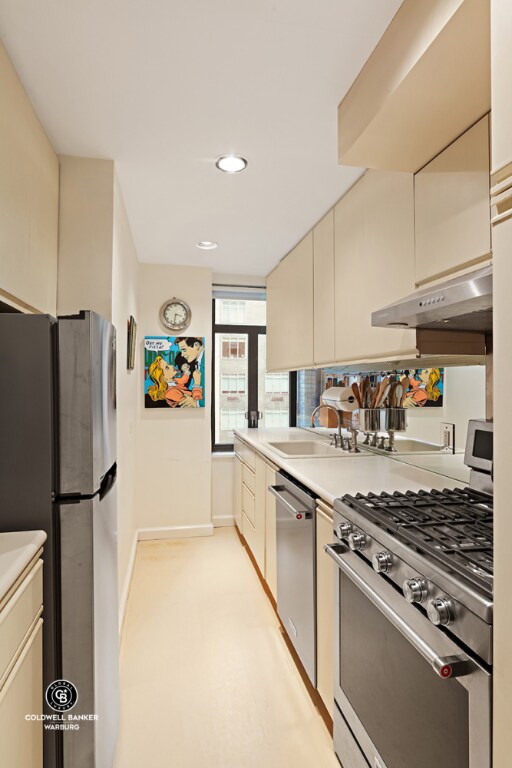 kitchen featuring sink, stainless steel appliances, and cream cabinetry