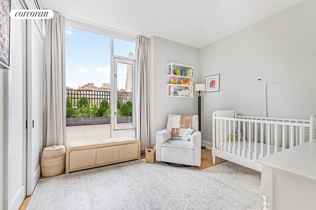 bedroom with expansive windows and light hardwood / wood-style flooring