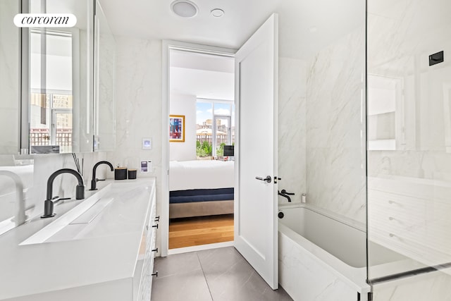 bathroom with vanity, a tub, and tile patterned floors