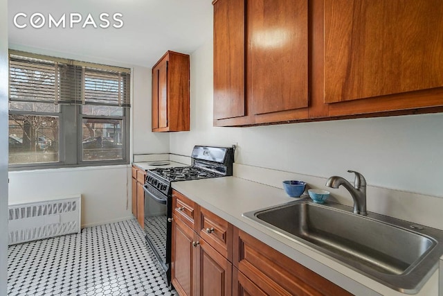 kitchen featuring sink, radiator heating unit, and black gas range