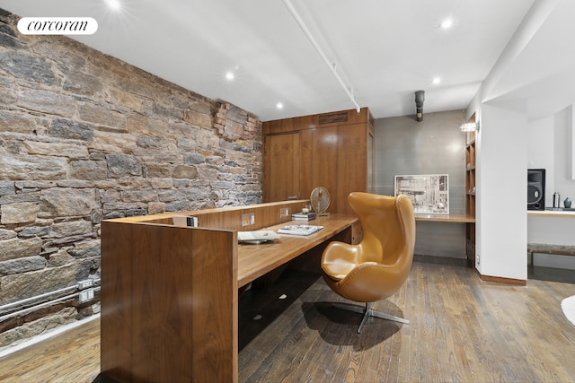 home office with wood-type flooring and built in desk