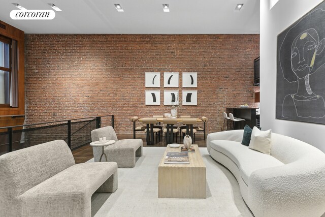 bedroom with dark wood-type flooring, ceiling fan, and brick wall