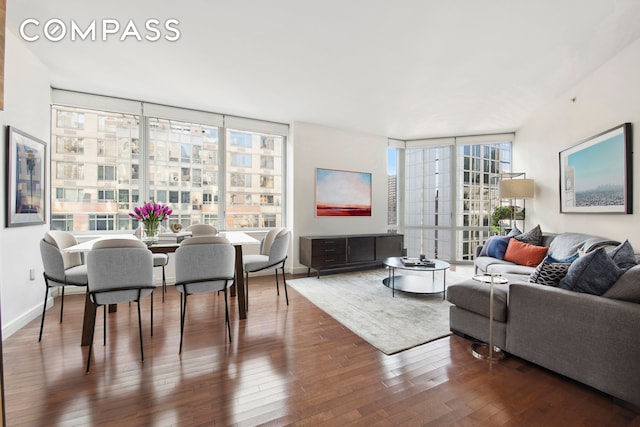 living area with floor to ceiling windows, baseboards, and hardwood / wood-style floors