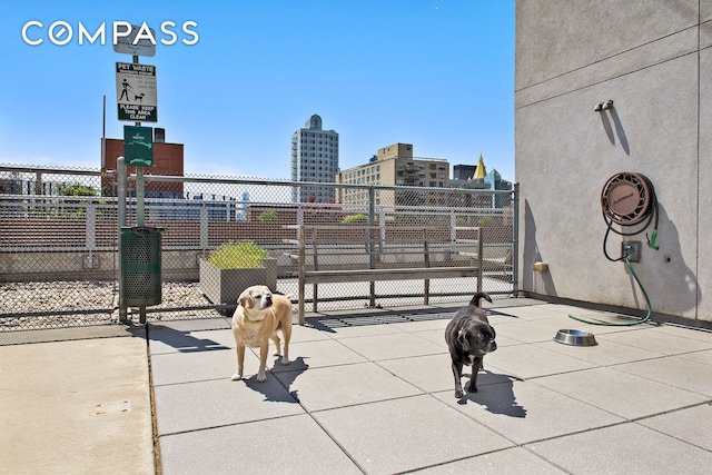 view of patio / terrace featuring a gate, a view of city, and fence