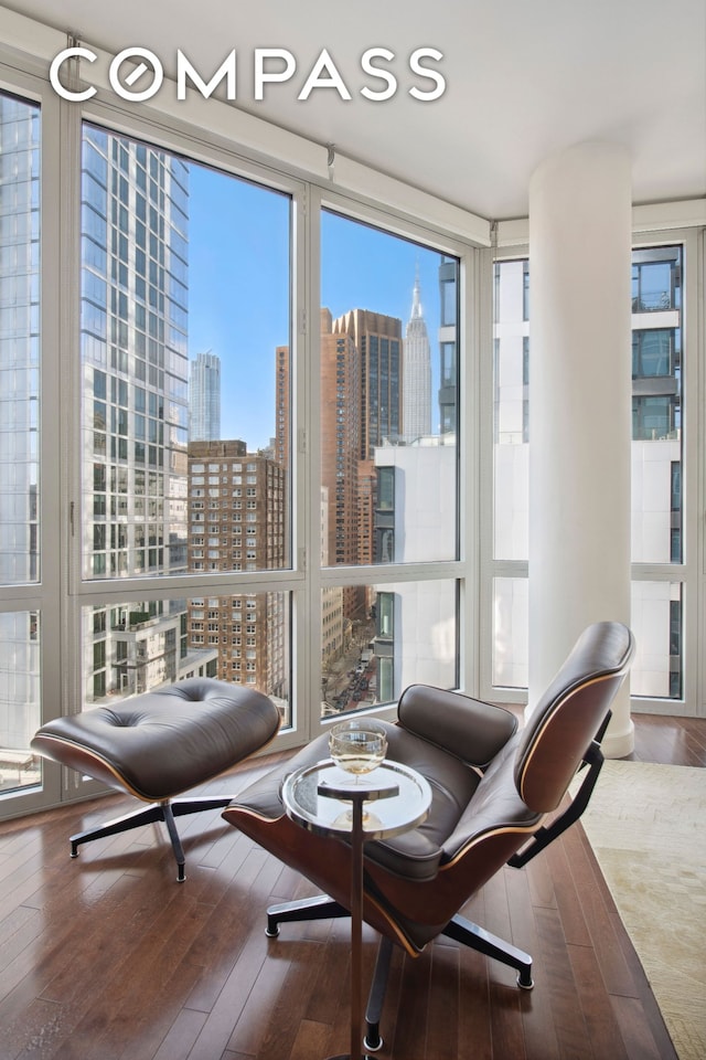 interior space featuring a view of city, hardwood / wood-style floors, and a wall of windows