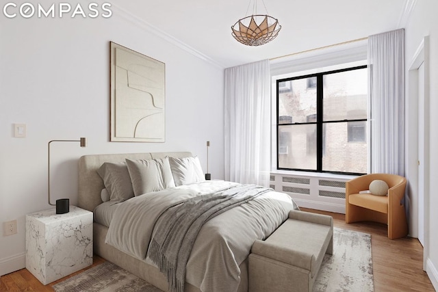 bedroom featuring ornamental molding and light wood-type flooring