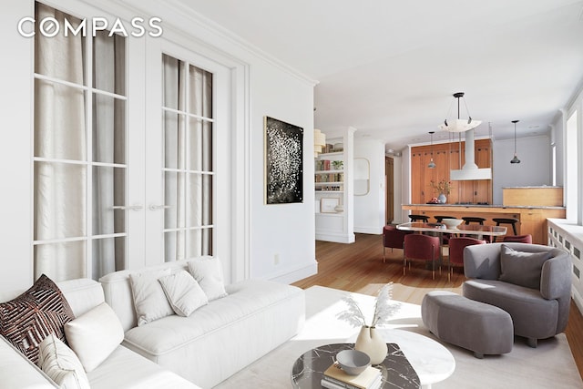 living area with crown molding and wood finished floors