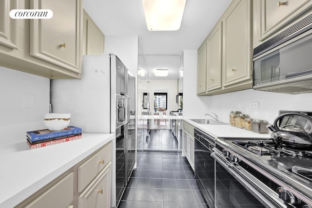 10 W 66th St Unit 12B, New York City, NY 10023 - kitchen featuring stainless steel appliances, light countertops, dark tile patterned flooring, and cream cabinets