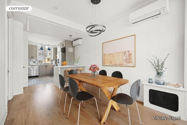 dining space featuring ornamental molding, a wall mounted AC, light wood-type flooring, and visible vents