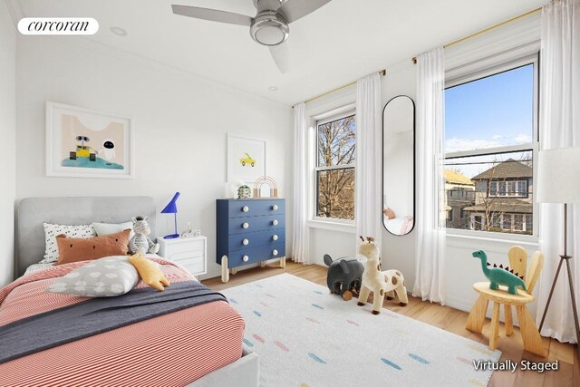 bedroom with wood finished floors, visible vents, and a ceiling fan