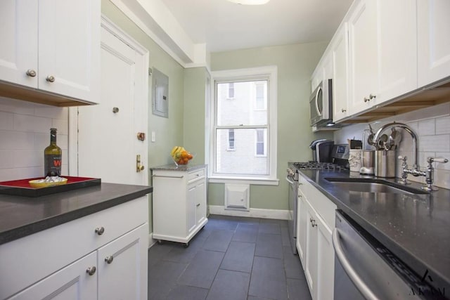 kitchen with appliances with stainless steel finishes, sink, white cabinets, and decorative backsplash