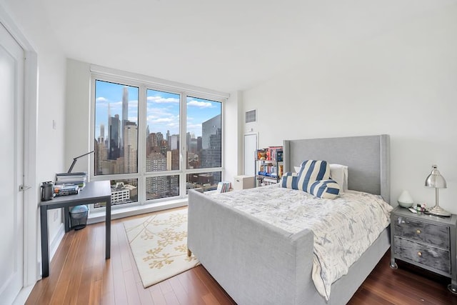 bedroom featuring wood finished floors and a view of skyline