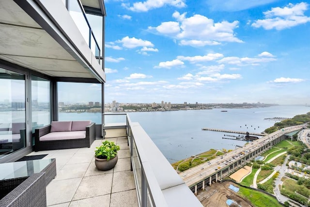 balcony featuring a water view and a city view