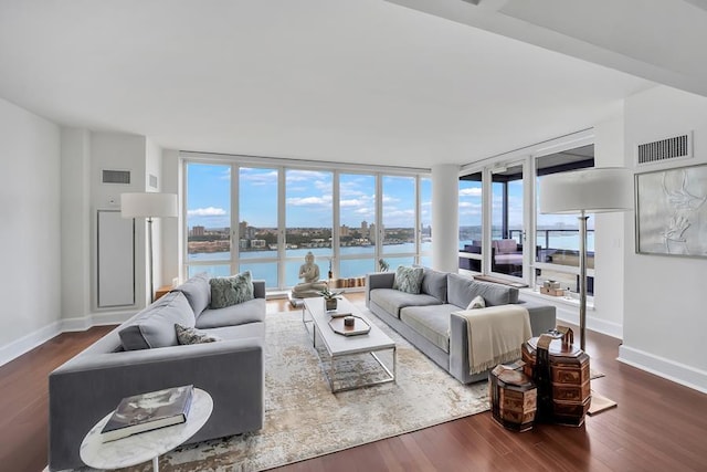 living area with dark wood finished floors, baseboards, and a water view