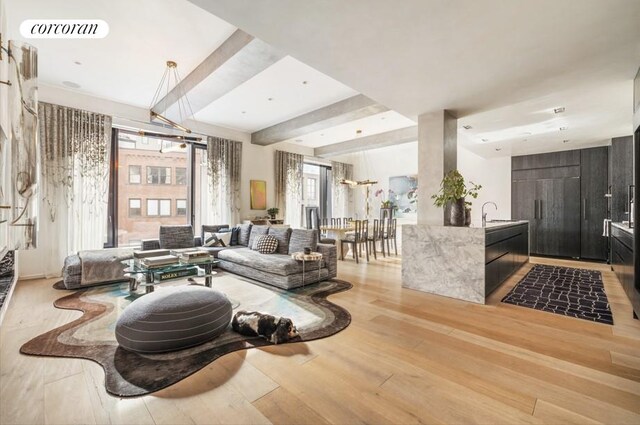 living room featuring beamed ceiling, hardwood / wood-style floors, and a notable chandelier