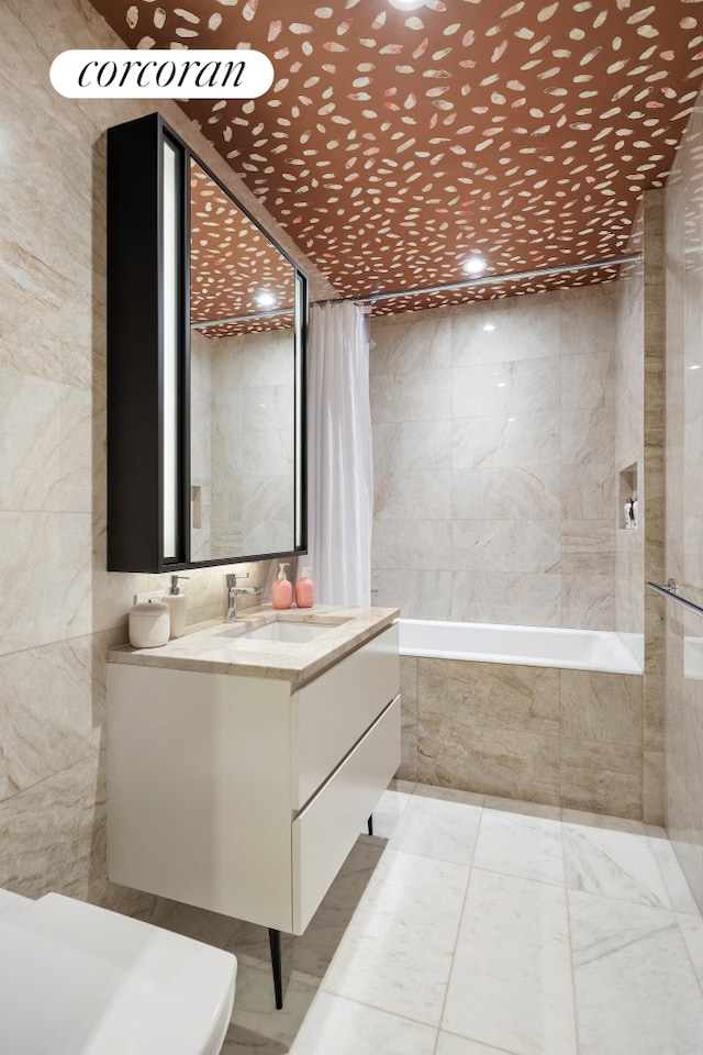 full bath featuring tiled shower / bath combo, tile walls, and vanity