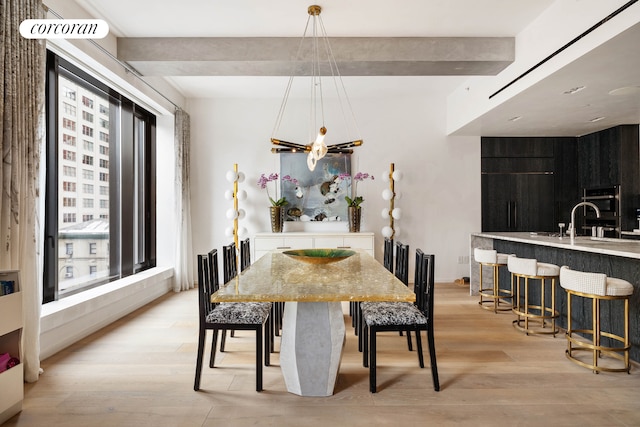 dining room featuring beam ceiling, visible vents, and light wood finished floors