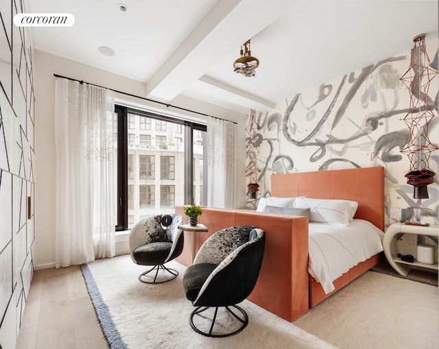 bedroom with beam ceiling and wood finished floors