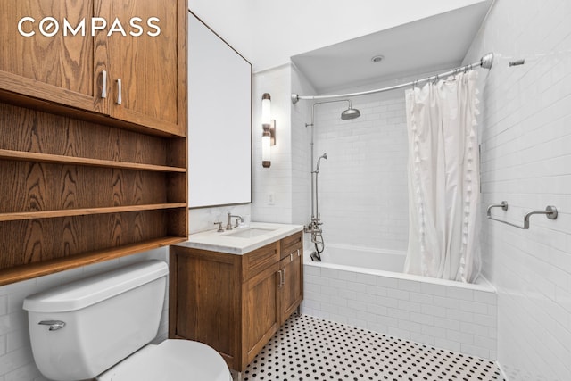 bathroom featuring toilet, tiled shower / bath, and vanity