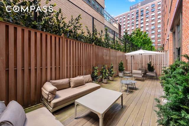 wooden deck with an outdoor living space and fence