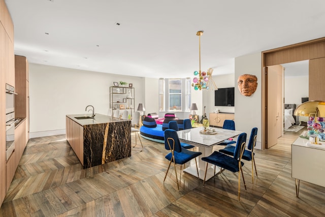 dining area featuring light parquet floors and sink