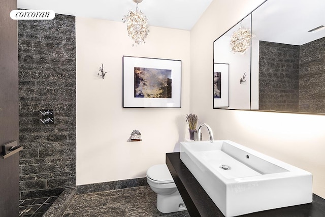 full bathroom with toilet, baseboards, visible vents, and tiled shower