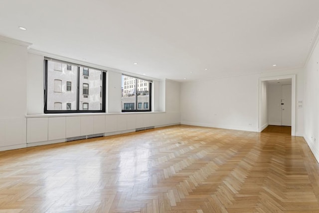 spare room with crown molding and light parquet floors