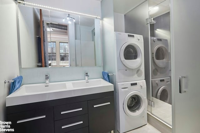 washroom with stacked washer and dryer and sink