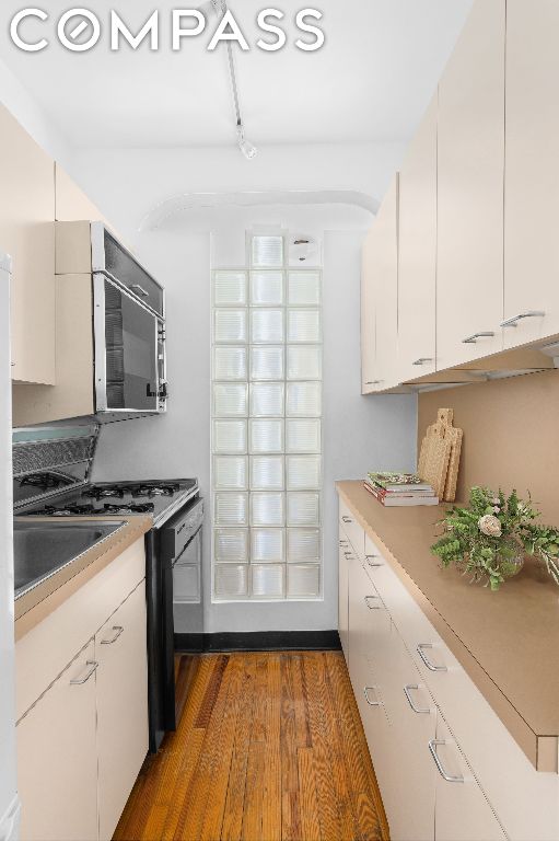 kitchen with white cabinetry, dark hardwood / wood-style floors, and sink