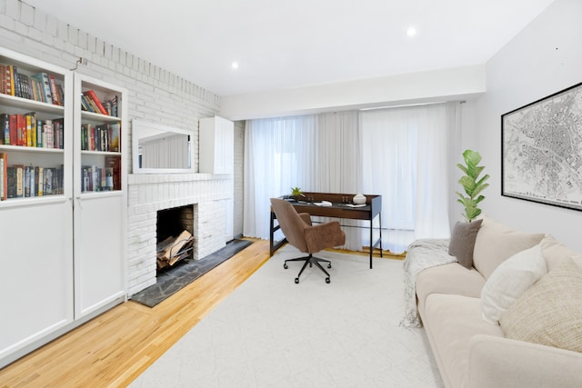 living area with a fireplace, recessed lighting, and wood finished floors