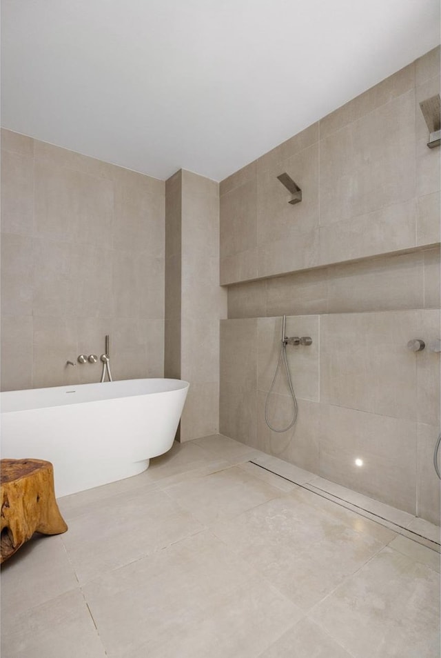 full bath featuring walk in shower, tile patterned flooring, a freestanding tub, and tile walls