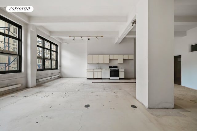 unfurnished living room featuring sink and beam ceiling