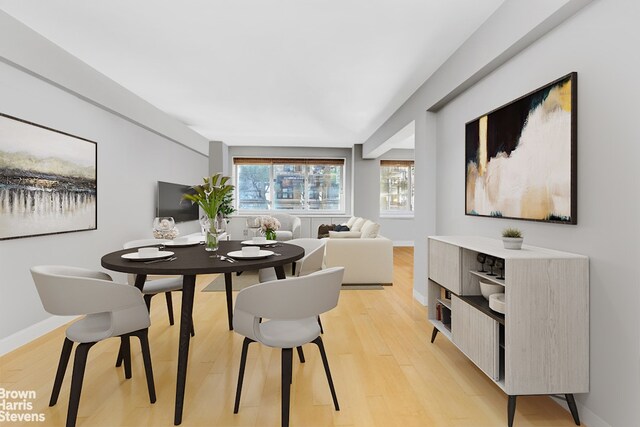 living area with baseboards and wood finished floors