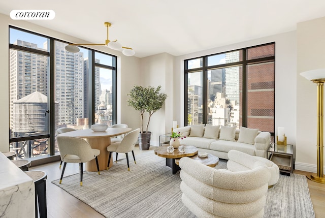 living room featuring a wealth of natural light, wood-type flooring, and floor to ceiling windows