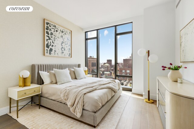 bedroom featuring wood-type flooring and expansive windows