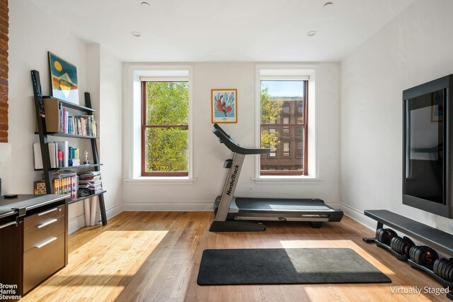 workout area with light hardwood / wood-style floors